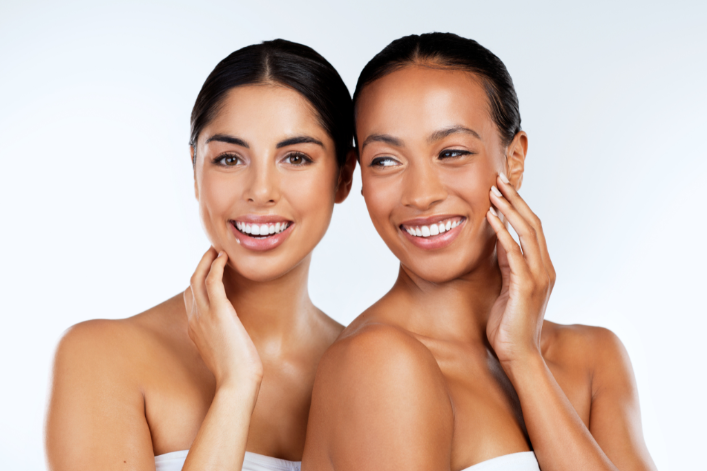 Two women with radiant, glowing skin smiling, showcasing the benefits of peptides for enhancing skin health and overall wellness.