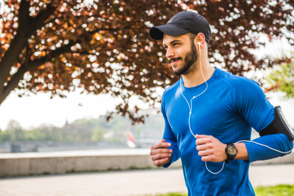 Young man jogging outdoors in a park, showing the positive effects of Hormone Therapy for Men on energy and fitness.