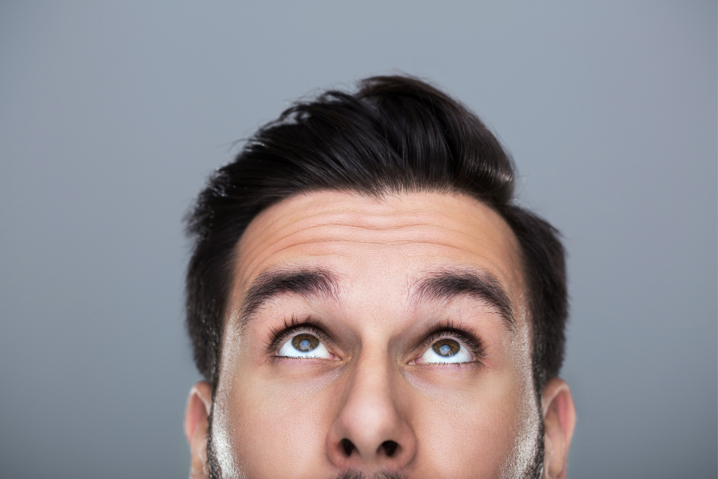 Man looking up thoughtfully, considering the benefits of Natural Hormone Therapy for hormone balance.